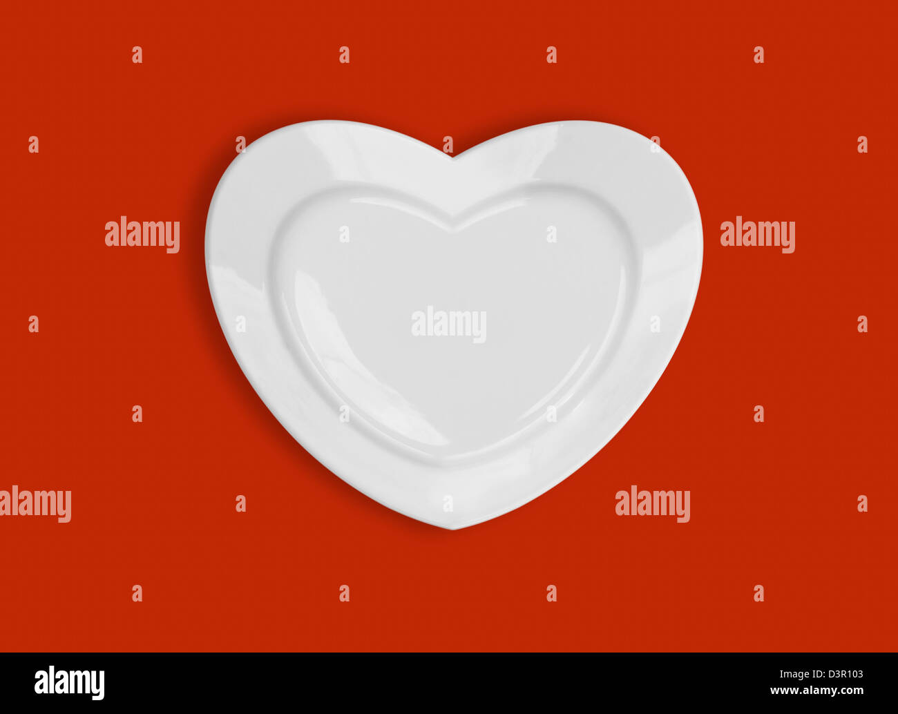Plaque en forme de coeur sur fond rouge Banque D'Images