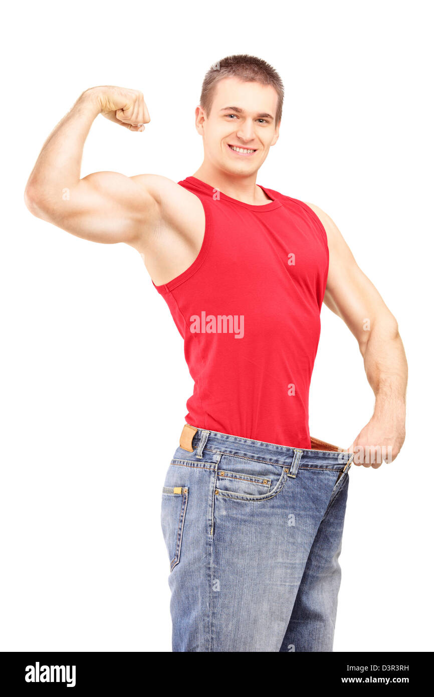La perte de poids l'homme dans une vieille paire de jeans montrant son  corps musclé isolé sur fond blanc Photo Stock - Alamy