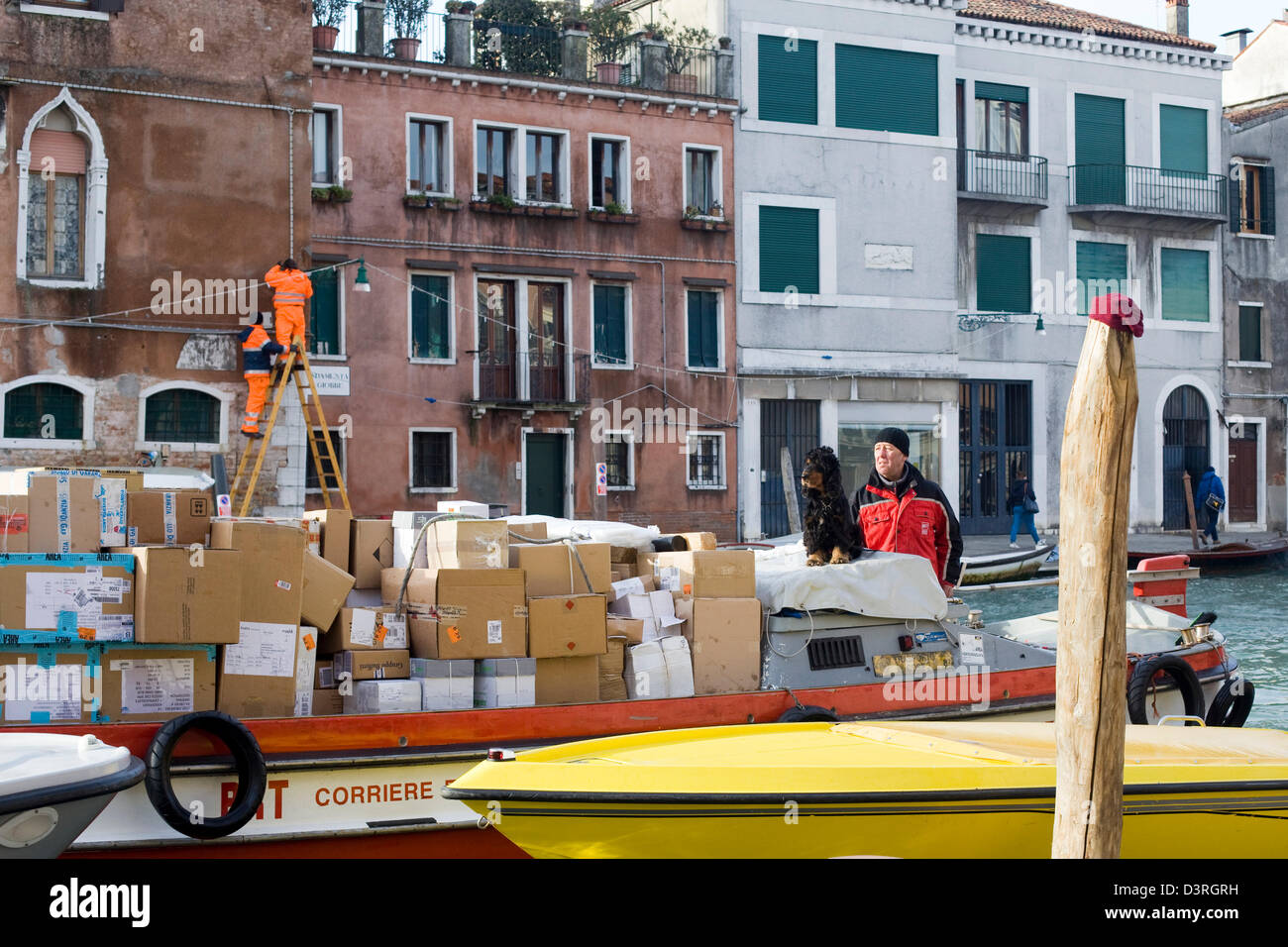 L'homme annonce à son chien le transport des marchandises sur un bateau dans la ville Venise Italie Banque D'Images