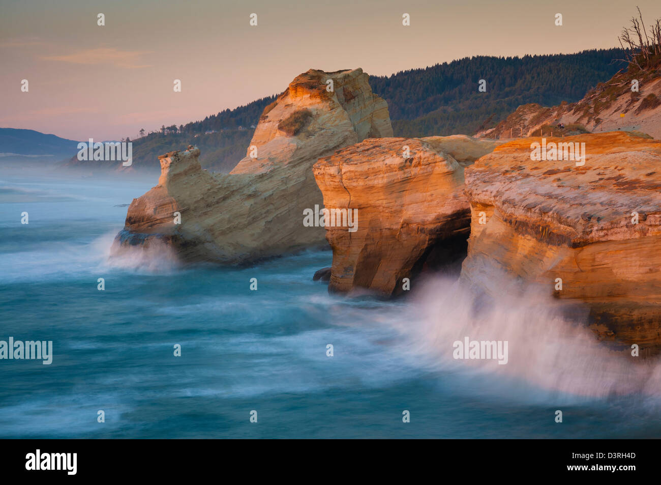 Vagues se briser sur les falaises au coucher du soleil, Cape Kiwanda, centre de l'Oregon Coast. Banque D'Images