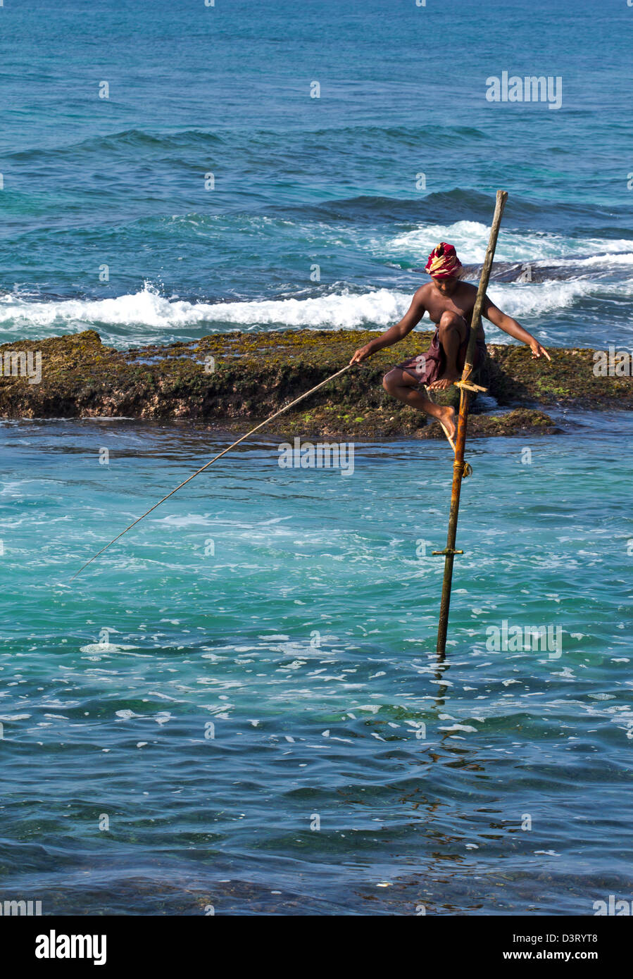 Pêcheur SUR PILOTIS DE SRI LANKA AVEC LA TIGE ET LA PÊCHE À LA LIGNE LES EAUX DE L'OCÉAN INDIEN Banque D'Images