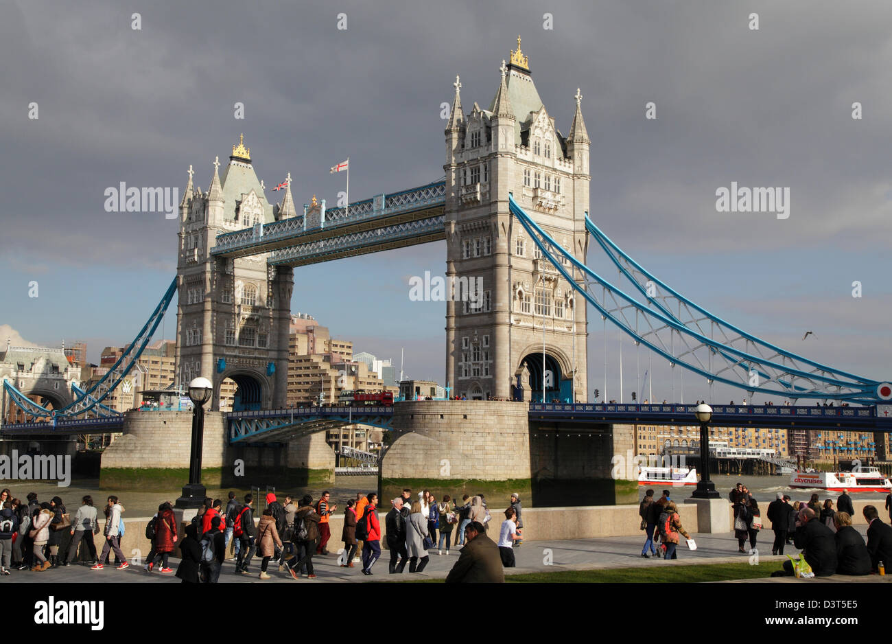 Les touristes à marcher le long de la rive sud, sur la journée d'hiver ensoleillée à Tower Bridge London England UK GO Banque D'Images