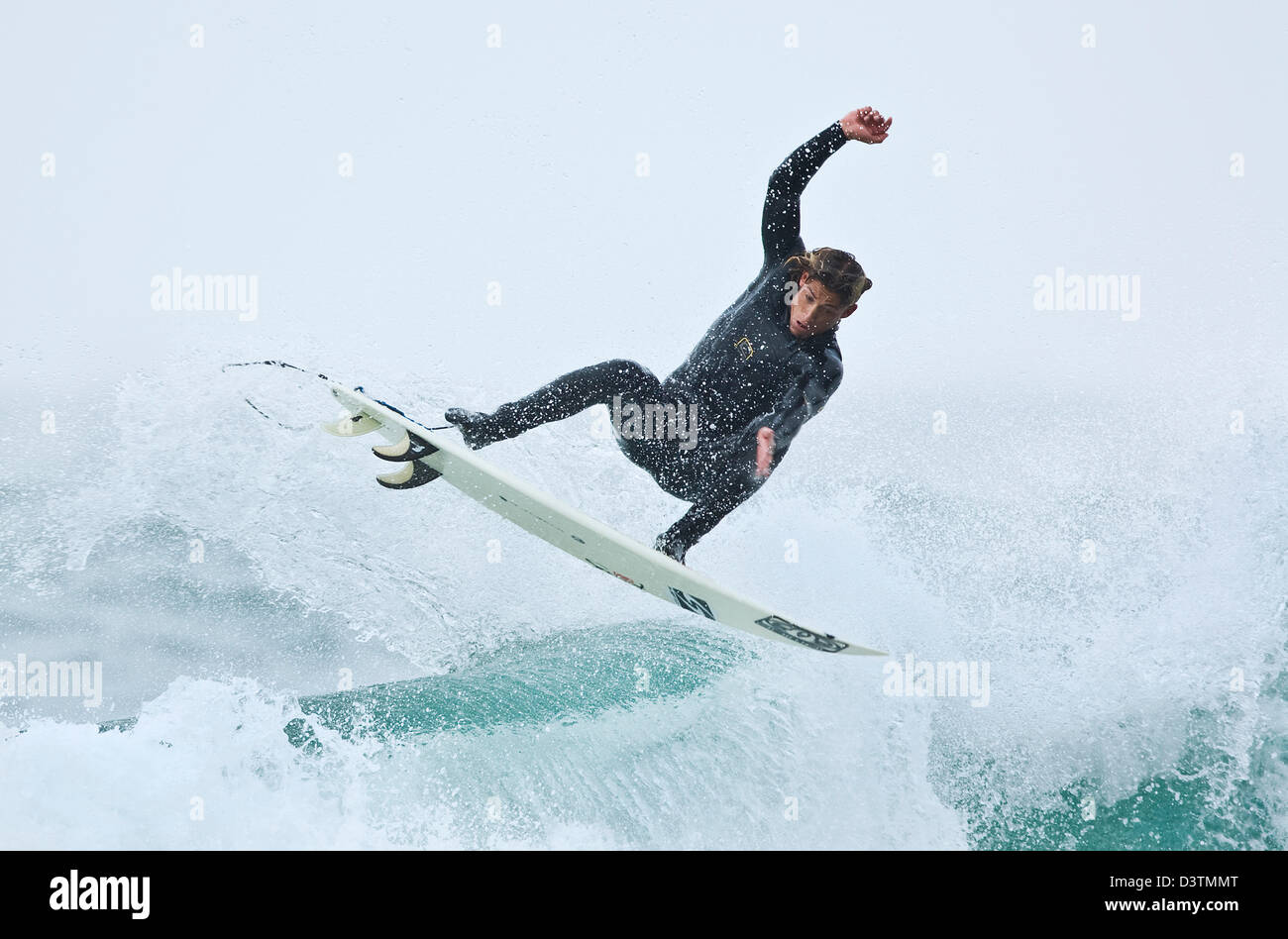Surfer mid air jump, St Agnes, Cornwall, UK Banque D'Images