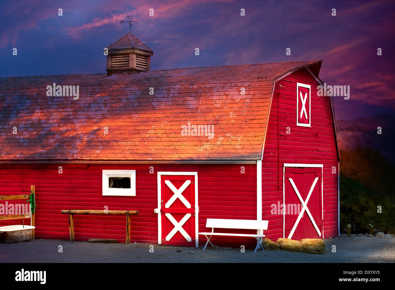 Vieille Grange rouge avec banc et bien Banque D'Images