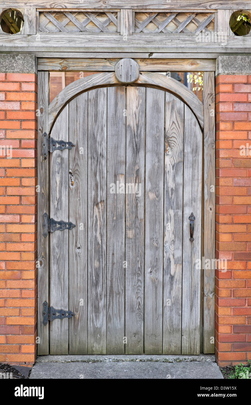Porte en bois avec dessus arrondi au mur de brique de près, une porte de  jardin fermé et verrouillé Photo Stock - Alamy