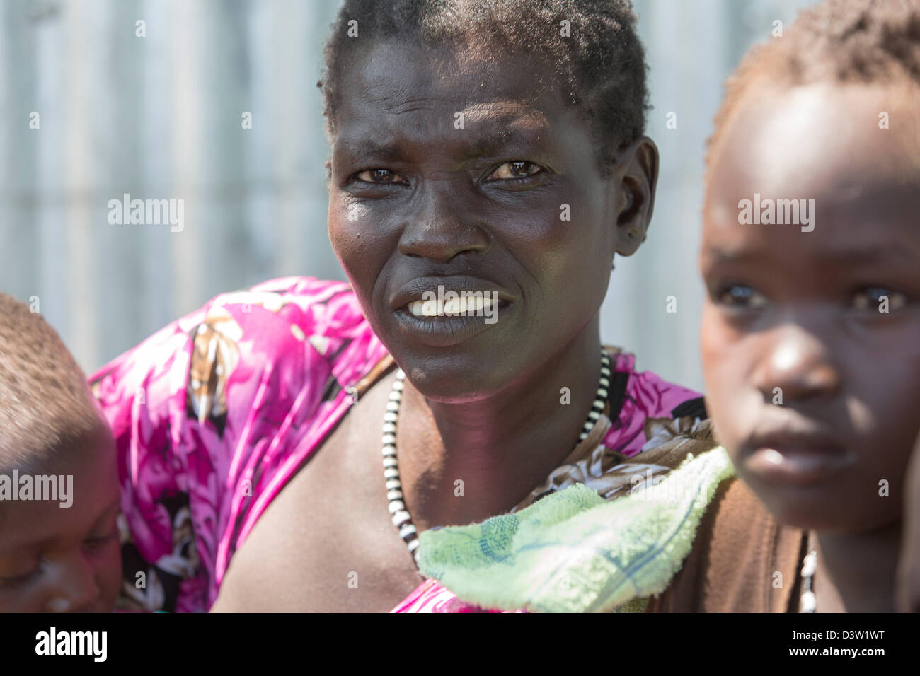 BOR, SOUDAN DU SUD, 19 novembre 2012 : Karok Mumayo, 35 ans, avec son fils Konyi, 3 ans, et sa fille Naya, 7 ans. Ils ont été enlevés en juin 2011 par les membres de la tribu Lol Nuer et détenus pendant un an avant d'être libérés par l'armée sud-soudanaise. Ils sont maintenant à l'International Care Centre. Ce projet ramène les personnes enlevées dans leurs familes. Les enfants ont été enlevés lors du récent conflit intertribal entre les communautés Nuer et Merle. Banque D'Images