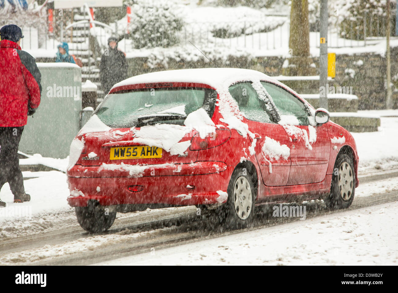 Les voitures qui circulent dans la neige lourde à Ambleside, Lake District, UK. Banque D'Images