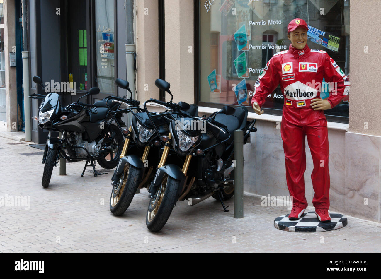 Un mannequin grandeur nature et les motos à l'extérieur d'un magasin de moto. Banque D'Images