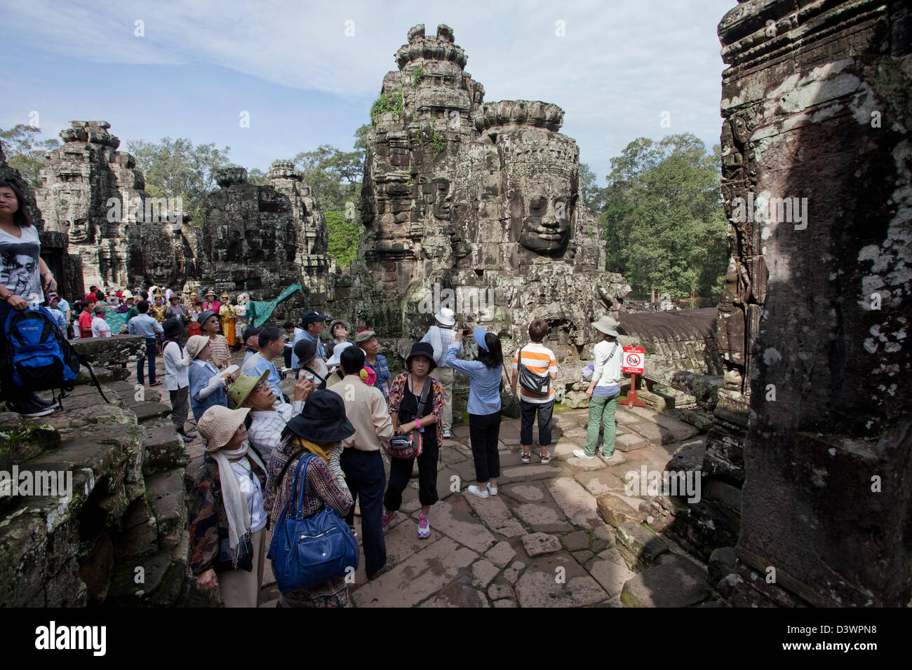 Visages sculptés dominent Bayon, le premier temple à Angkor Thom, un temple situé près de l'Angkor Wat, Siem Reap, Cambodge. Banque D'Images