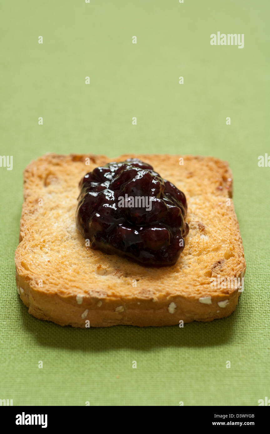 Vue rapprochée de l'italien fait main bio confiture de petits fruits mélangés sur un toast melba Banque D'Images