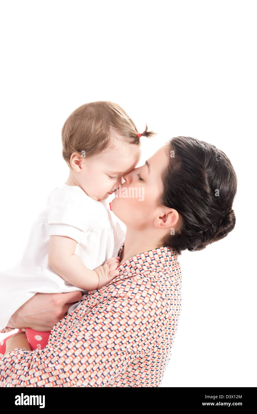 Mère embrassant son bébé fille isolée sur fond blanc Banque D'Images