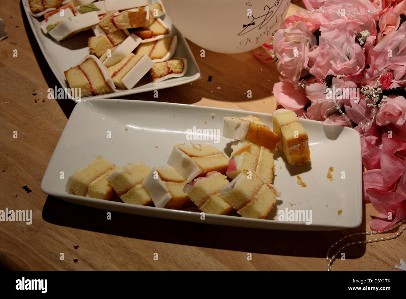 Le gâteau coupé en tranches, présentés sur un côté d'un ballon et d'un bouquet de fleurs. Banque D'Images