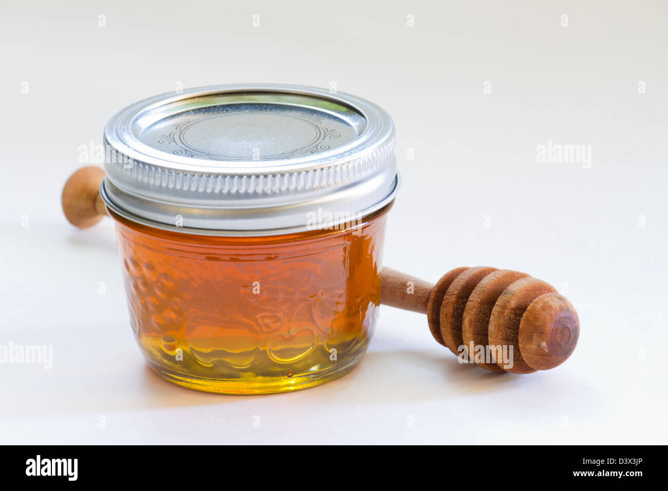 Drizzler miel en bois et miel bio Banque D'Images