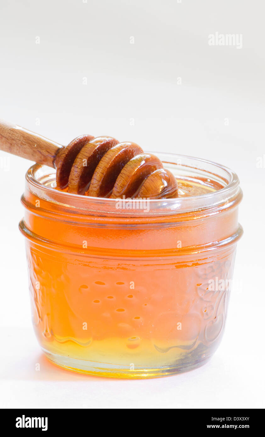Drizzler en bois dans le pot de miel Banque D'Images