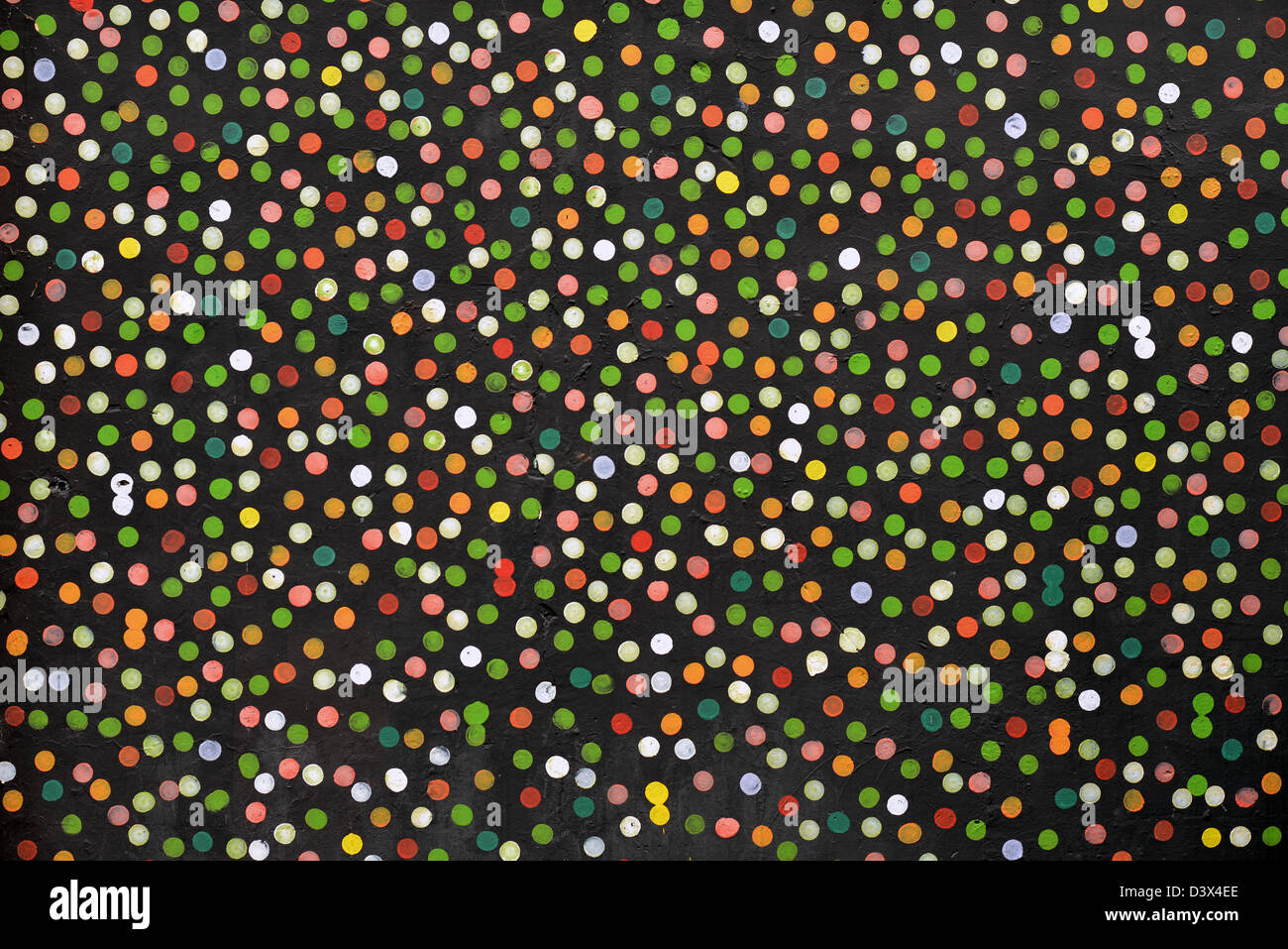 Abstract dotted background, points colorés peints sur le mur noir. Banque D'Images