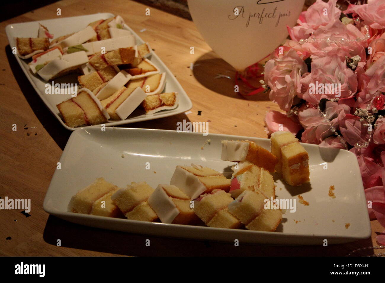 Le gâteau coupé en morceaux présentés sur une assiette, à côté d'un ballon et d'un bouquet. Banque D'Images