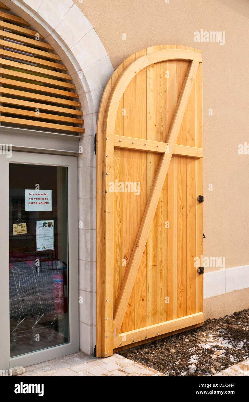 Nouveau bois cintrées portes doubles sur façade boutique - France. Banque D'Images