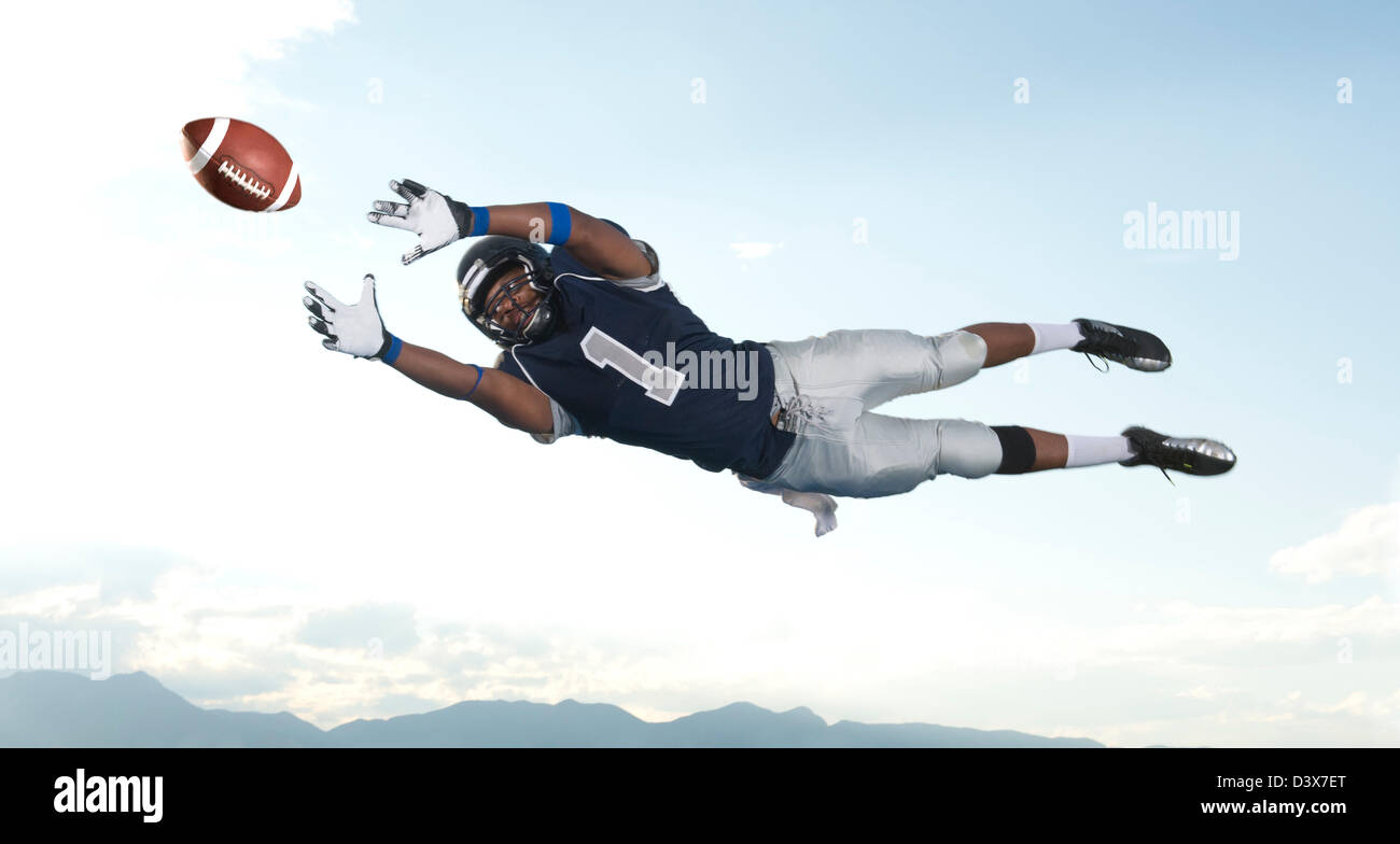 African American football player catching ball Banque D'Images