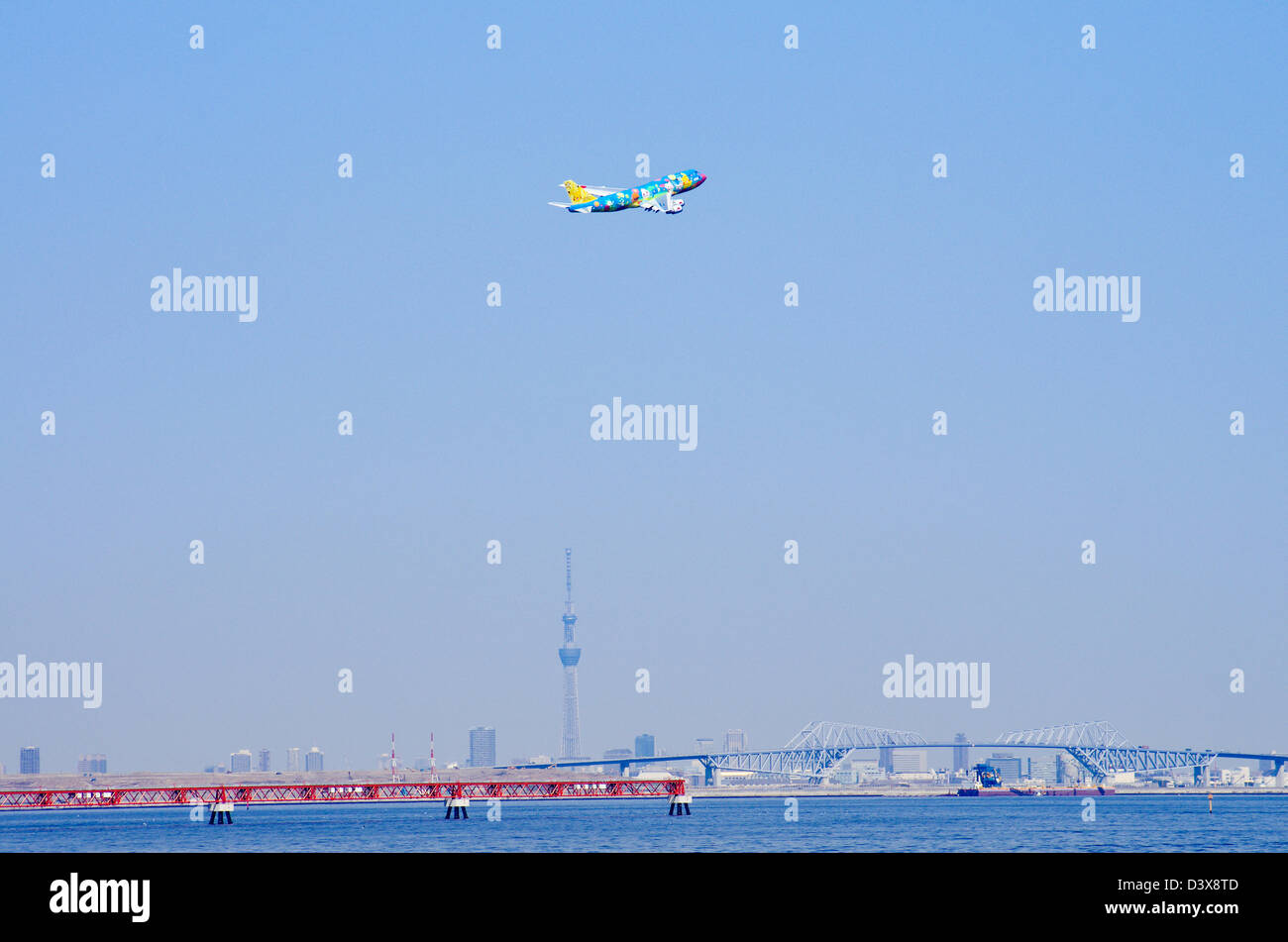 ANA Pokemon Jet au décollage à l'aéroport de Haneda avec Sky Tree et pont en arc-en-ciel en arrière-plan, Tokyo, Japon Banque D'Images