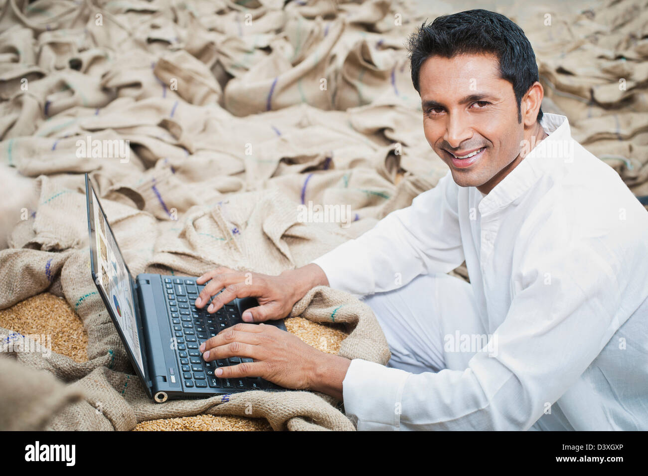 L'homme travaillant sur un ordinateur portable dans un marché des céréales, l'Anaj, Mandi, Sohna Gurgaon, Haryana, Inde Banque D'Images