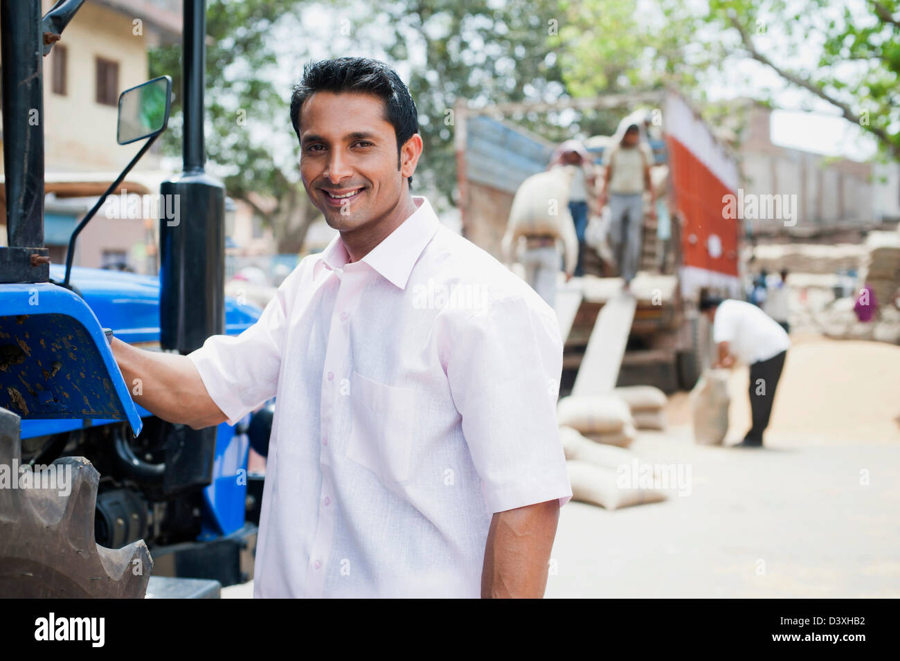 Homme debout près d'un tracteur, l'Anaj, Mandi, Sohna Gurgaon, Haryana, Inde Banque D'Images