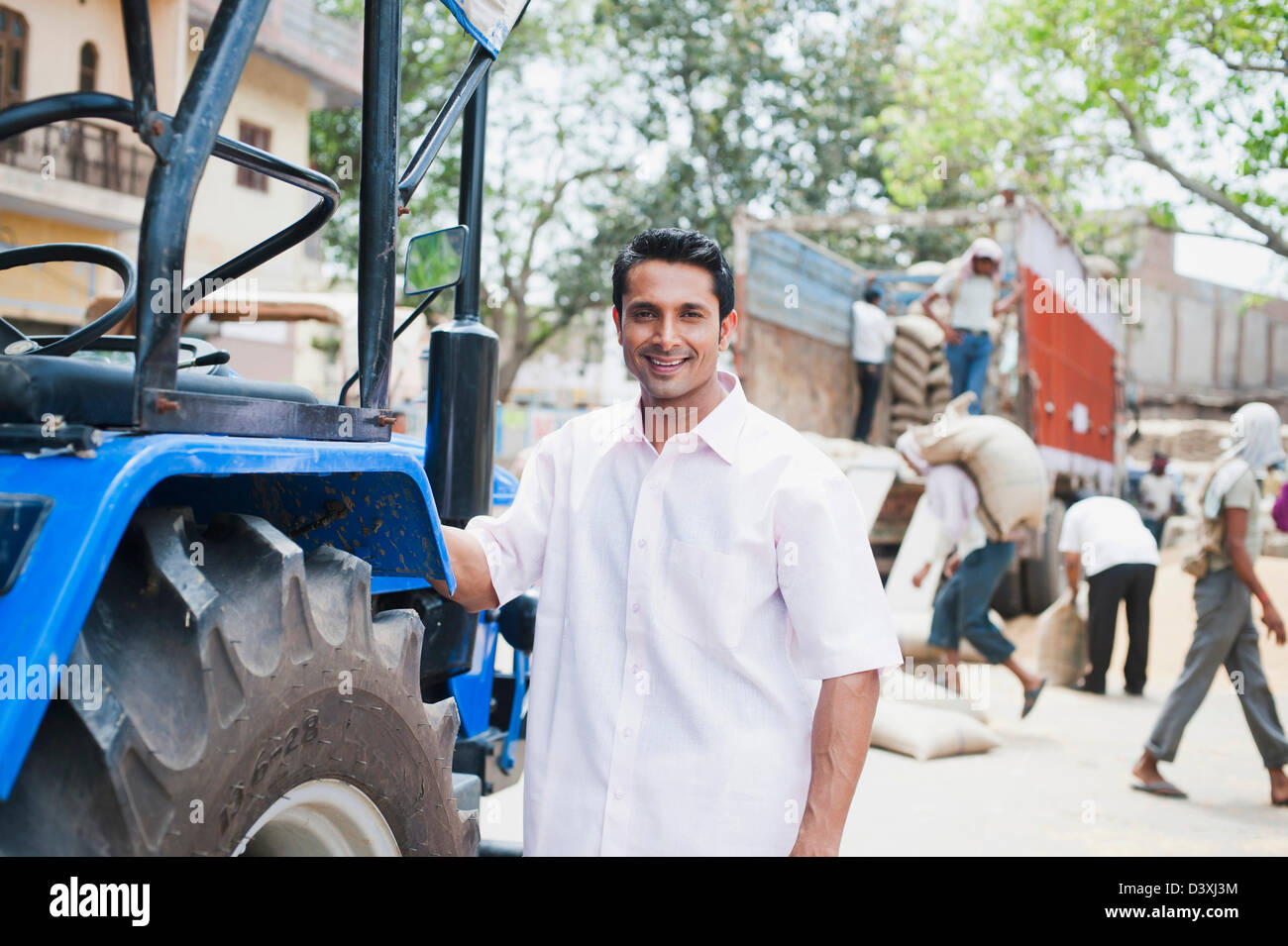 Homme debout près d'un tracteur, l'Anaj, Mandi, Sohna Gurgaon, Haryana, Inde Banque D'Images