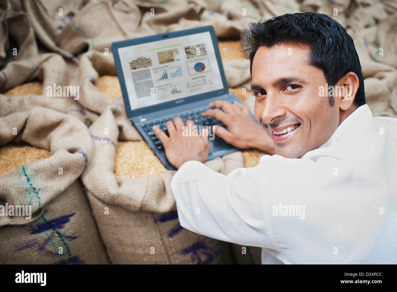 L'homme travaillant sur un ordinateur portable dans un marché des céréales, l'Anaj, Mandi, Sohna Gurgaon, Haryana, Inde Banque D'Images