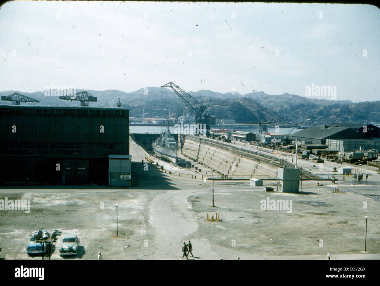 L'USS Kearsarge (CV-33) en cale sèche pour maintenance dans une chantier naval, avec des avions VF-53 préparés pour les opérations de porte-avions, mettant l'accent sur la maintenance des avions et des navires de la marine. Banque D'Images