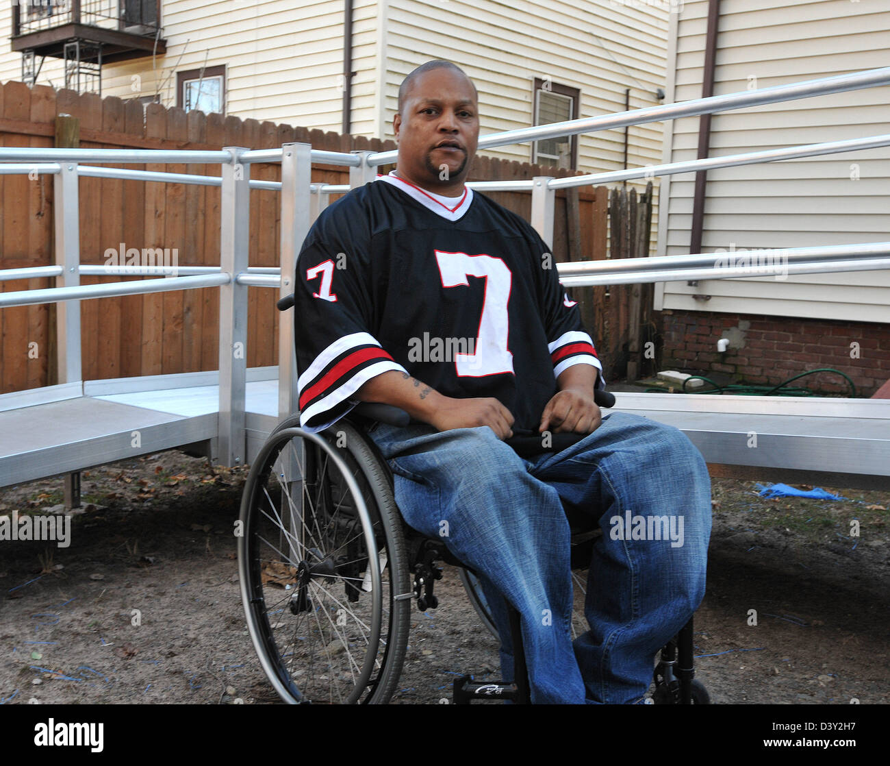 Jonathan Hicks, qui est paralysé de la taille vers le bas d'une blessure par balle il y a des années, est assis près de la rampe d'accès à son domicile. Banque D'Images