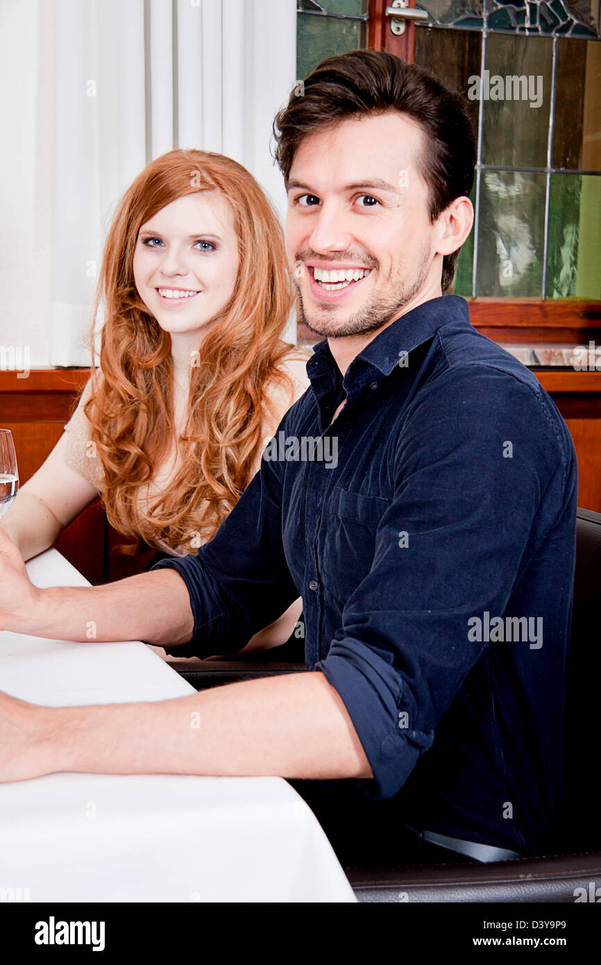 L'homme et de la femme dans le restaurant pour le dîner, boire du vin rouge et souriant Banque D'Images