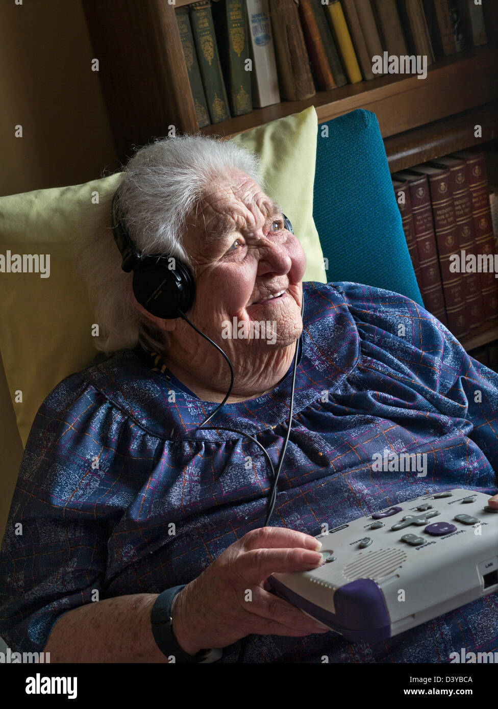 Dame âgée écouter un livre audio, avec un lecteur CD conçu pour une utilisation par les malentendants, aveugles ou malvoyants Banque D'Images