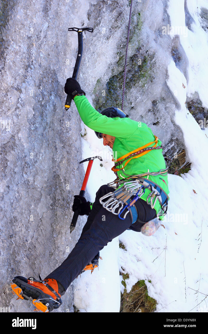 Alpiniste dans l'action avec deux axes sur une cascade de glace Banque D'Images