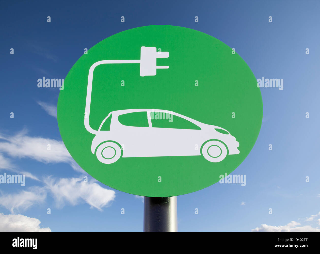 Panneau vert indiquant un point de recharge pour véhicules électriques, ciel bleu ensoleillé ajouté en post-production Banque D'Images