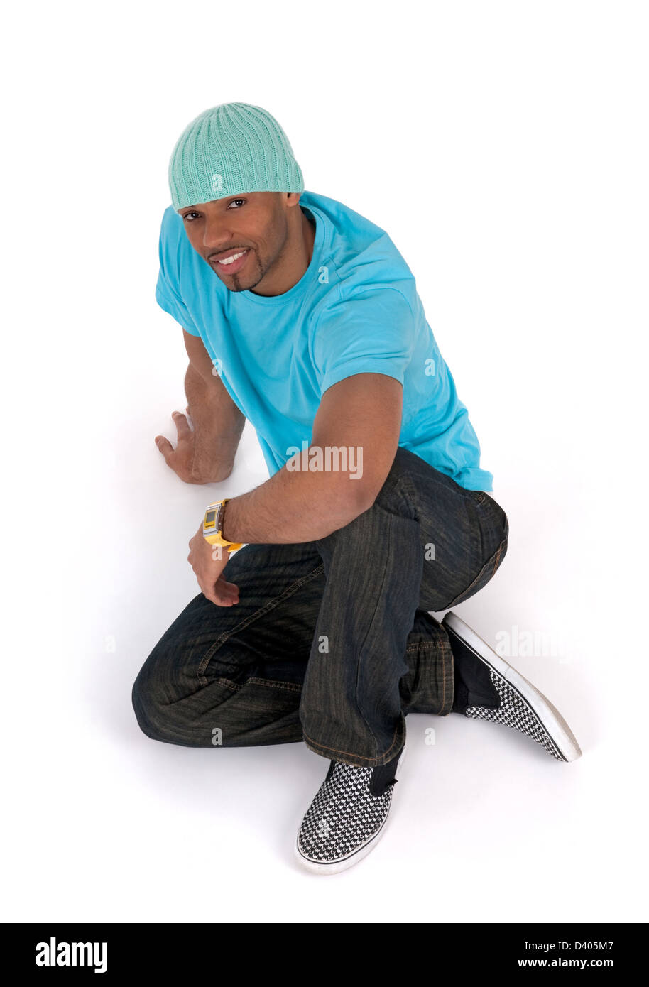 Jeune homme détendu dans un tee-shirt bleu assis sur le plancher, en  souriant. Isolé sur blanc Photo Stock - Alamy