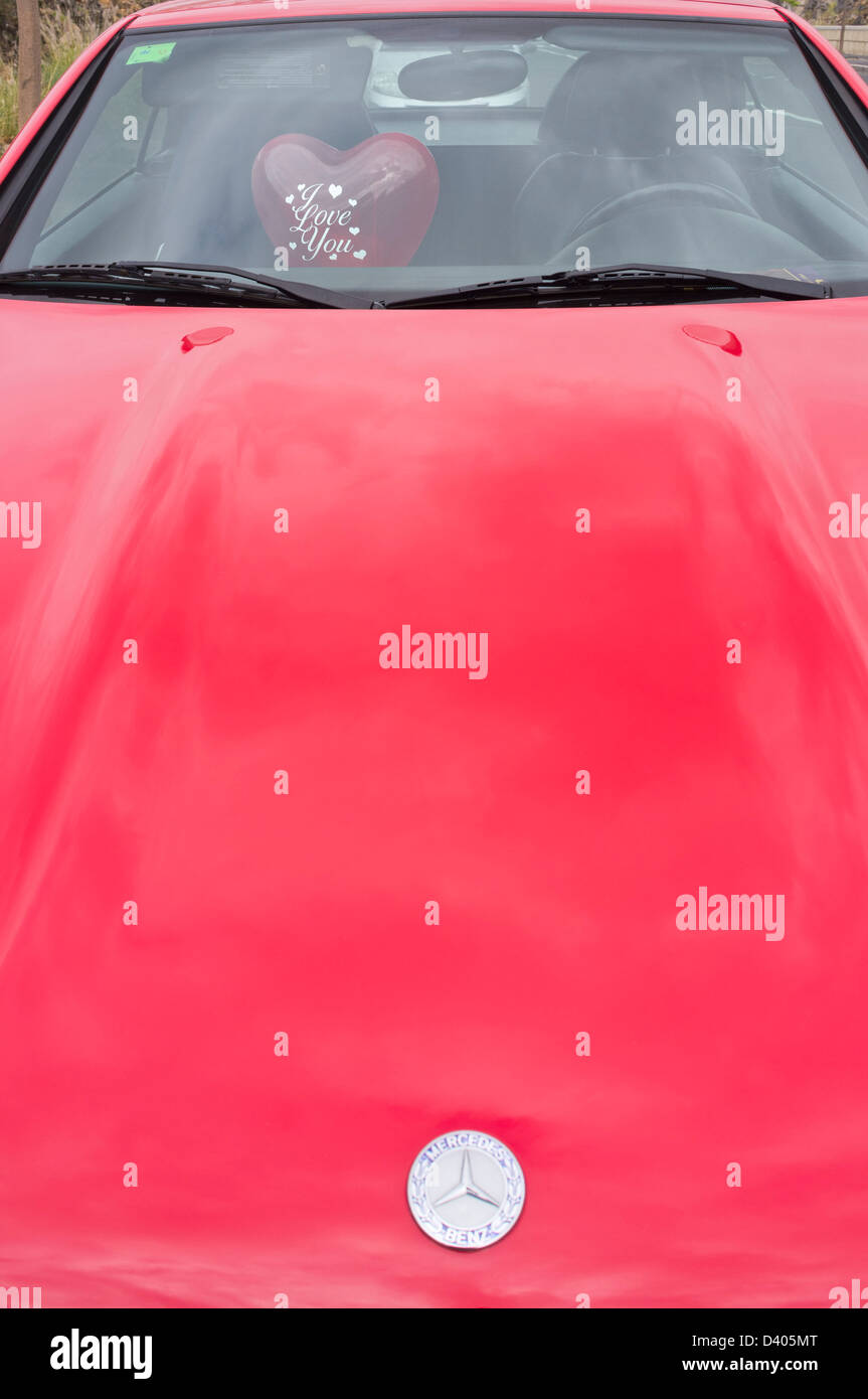 Ballon en forme de coeur rouge avec je Vous aime écrit sur l'intérieur d'une Mercedes rouge Banque D'Images