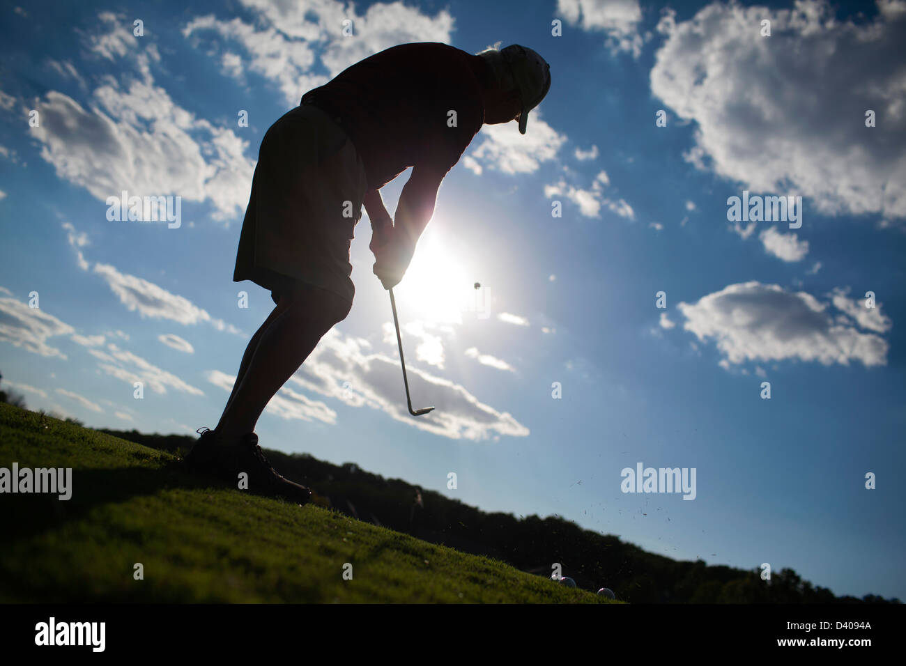 Un golfeur aîné emplacements sur un green à un practice de golf. Banque D'Images