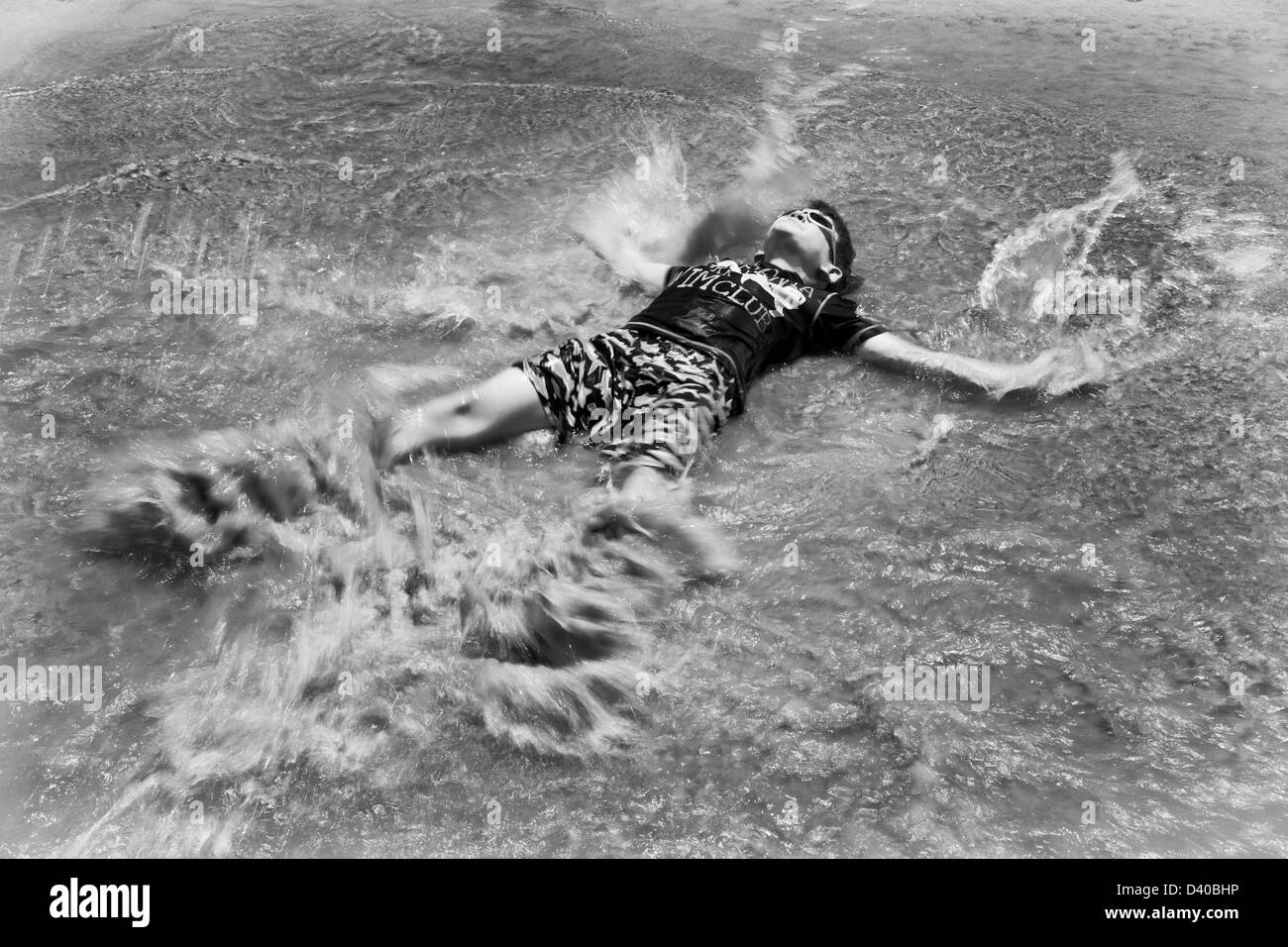 Energetic 8 ans homme enfant jouant dans l'eau sur la plage, l'action d'arrêt splashing mouvement, portant la protection contre le soleil, Hilton Head Island, SC US Banque D'Images