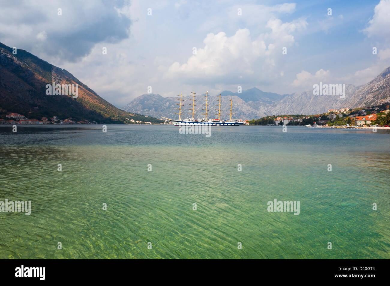 Bateau à voile dans les eaux calmes de la baie de Kotor au Monténégro en une journée ensoleillée, lumineuse avec ciel bleu et de beaux nuages blancs. Banque D'Images