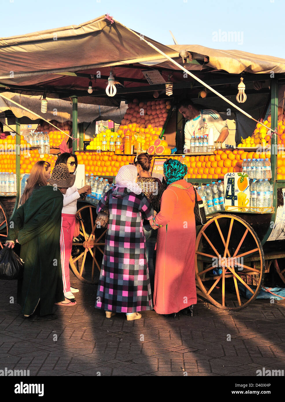 Les gens en face d'un vendeur de jus d'orange à la place Jemaa El Fna, Marrakech (Marrakech, Maroc) Banque D'Images