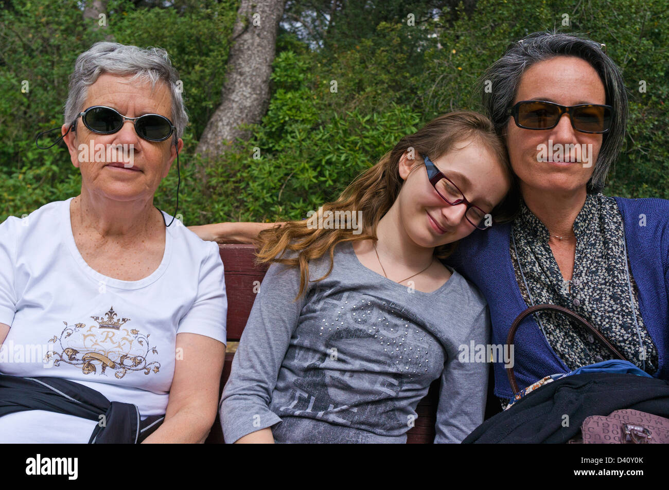 Portrait de famille - Senior Femme, Fille et petite-fille se reposant sur un banc dans un parc public Banque D'Images