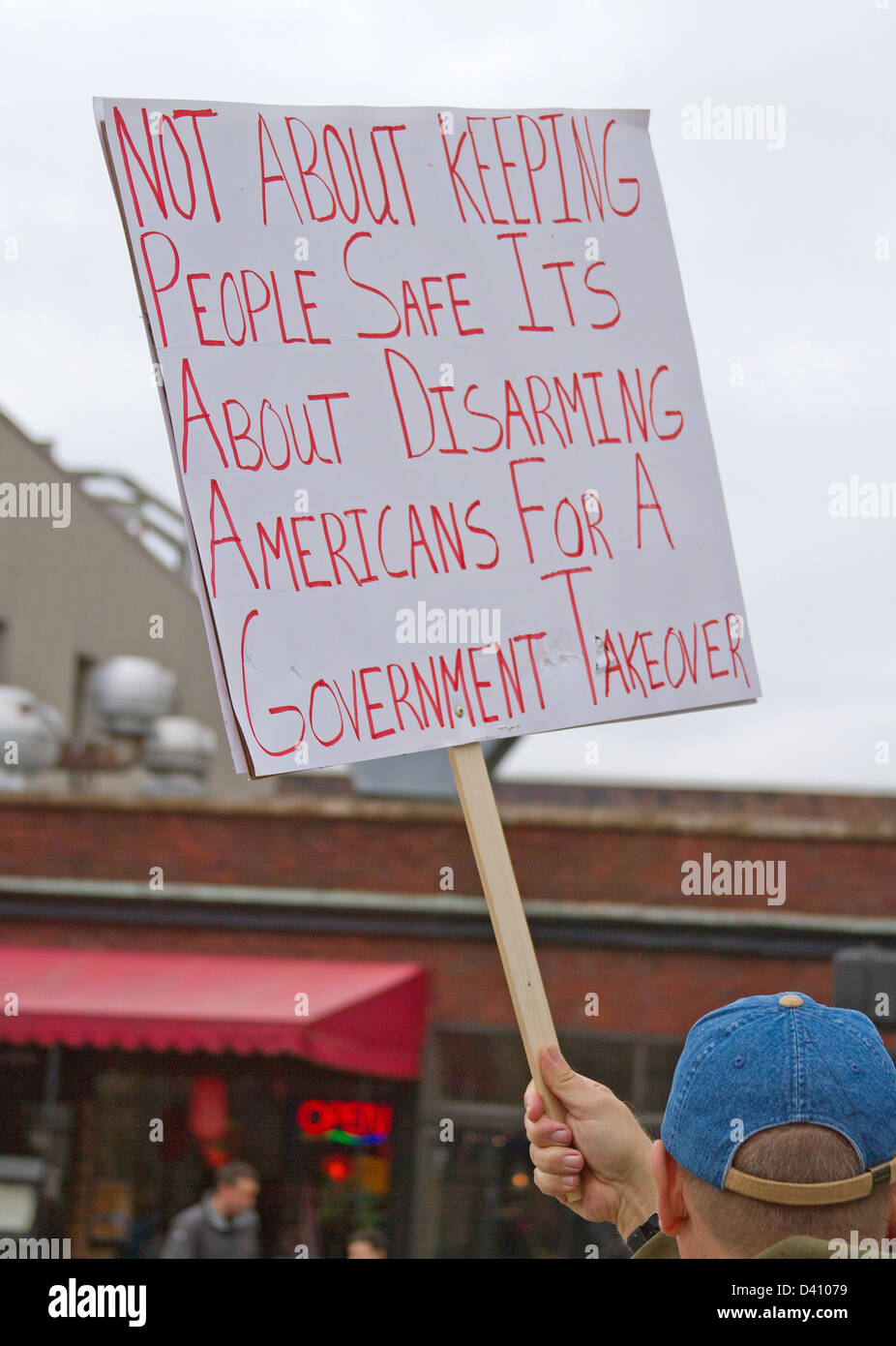 Le contrôle des armes à feu du gouvernement américain avec avertissement signe manifestant de mainmise gouvernementale au rassemblement à Asheville, NC, février 23, 2013 Banque D'Images