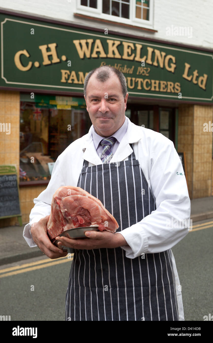 Roger Boucher Wakeling avec coupe de viande à l'extérieur de son magasin à Farncombe Banque D'Images