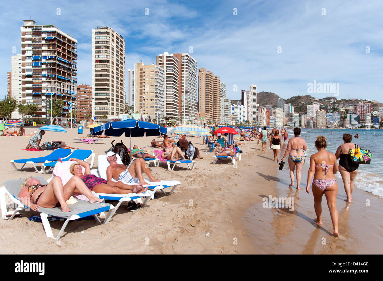 Les touristes se détendre sur des chaises longues à la plage, Benidorm, Costa Blanca, Espagne Banque D'Images