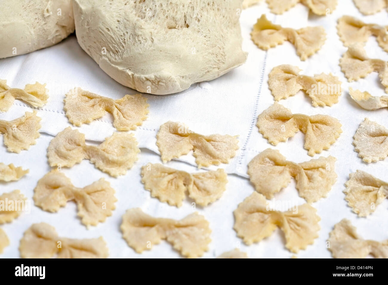Matières des pâtes en forme de nœud papillon sur une nappe blanche. La  cuisine traditionnelle italienne Photo Stock - Alamy
