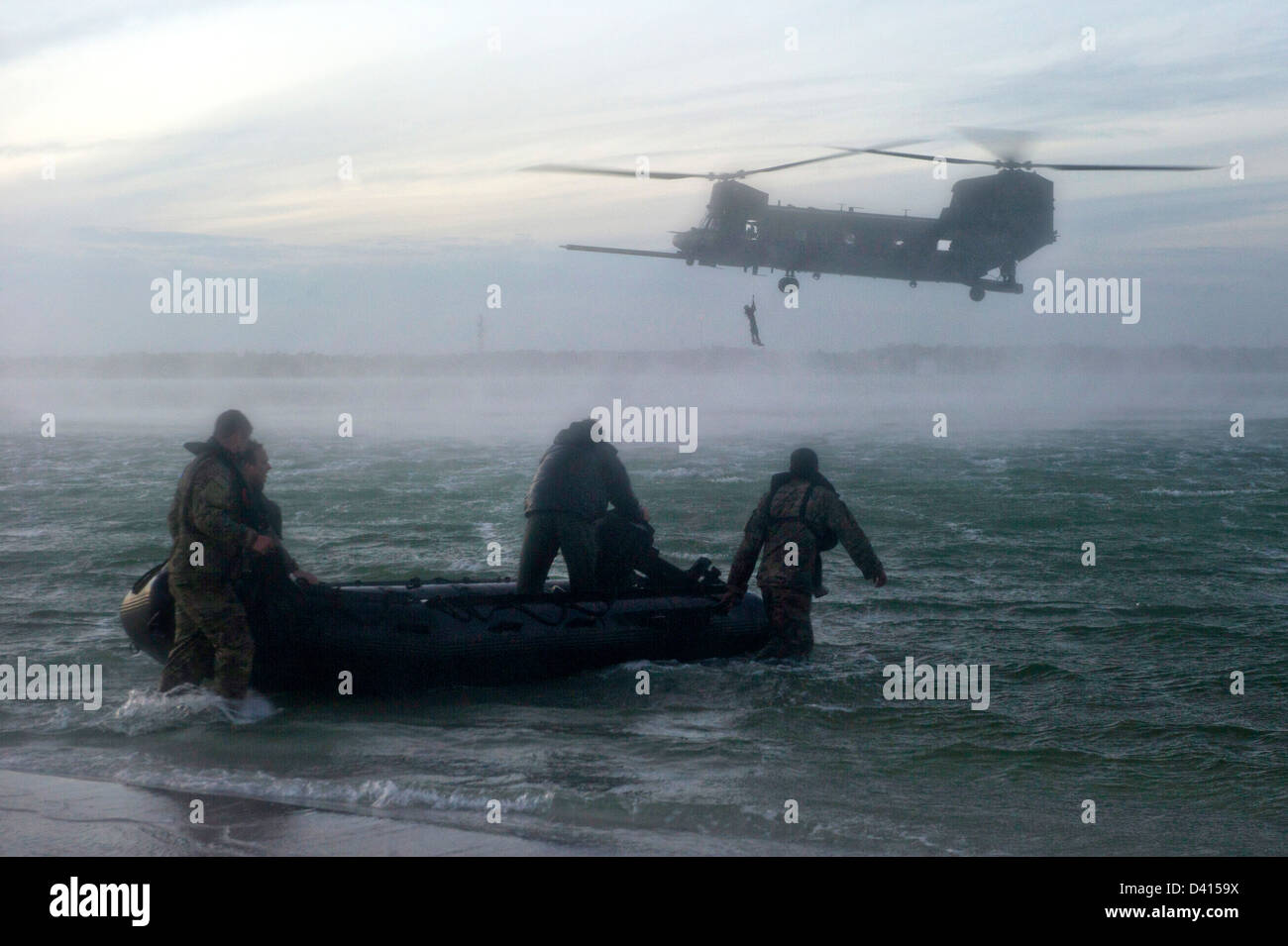 Les Forces spéciales US Green Beret soldats se préparent à entrer dans l'eau tandis que d'un hélicoptère CH-47 Chinook mène des opérations de levage, 6 février 2013 à la base aérienne d'Eglin, en Floride. Bérets verts pratiqué l'insertion dans l'eau après le déploiement d'un Zodiac gonflable. Helocasts permettent d'insérer des petites unités dans une zone militaire de l'opération par hélicoptère pour effectuer des missions. Banque D'Images