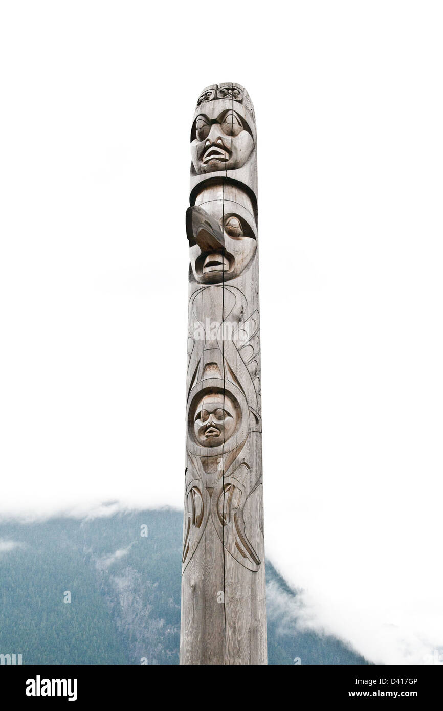 Un totem sculpté dans la tradition Nuxalk dans la Great Bear Rainforest sur la commune de Bella Coola, en Colombie-Britannique, Canada. Banque D'Images