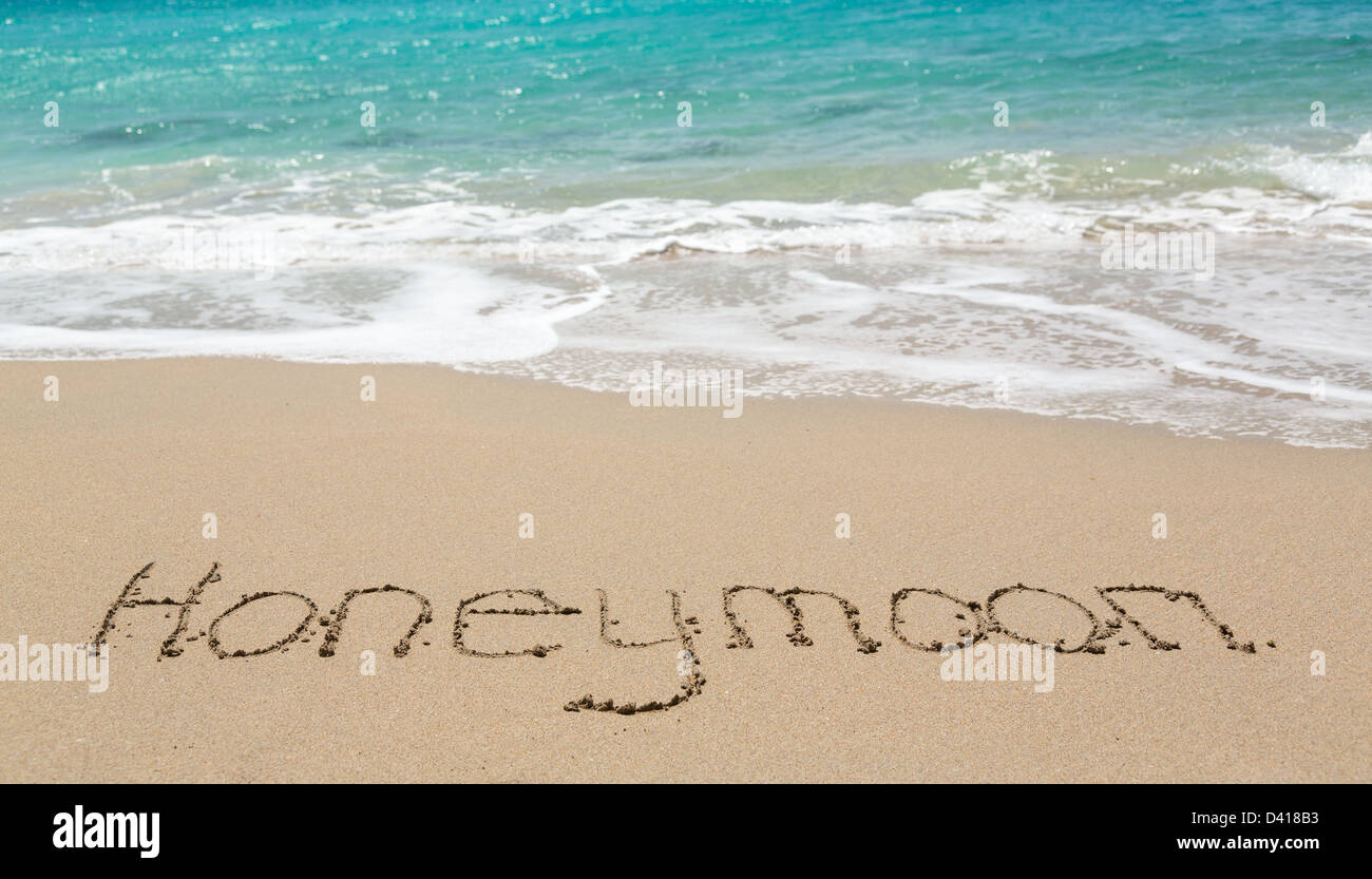 Mots écrits en lune de miel sur une plage tropicale de sable Banque D'Images
