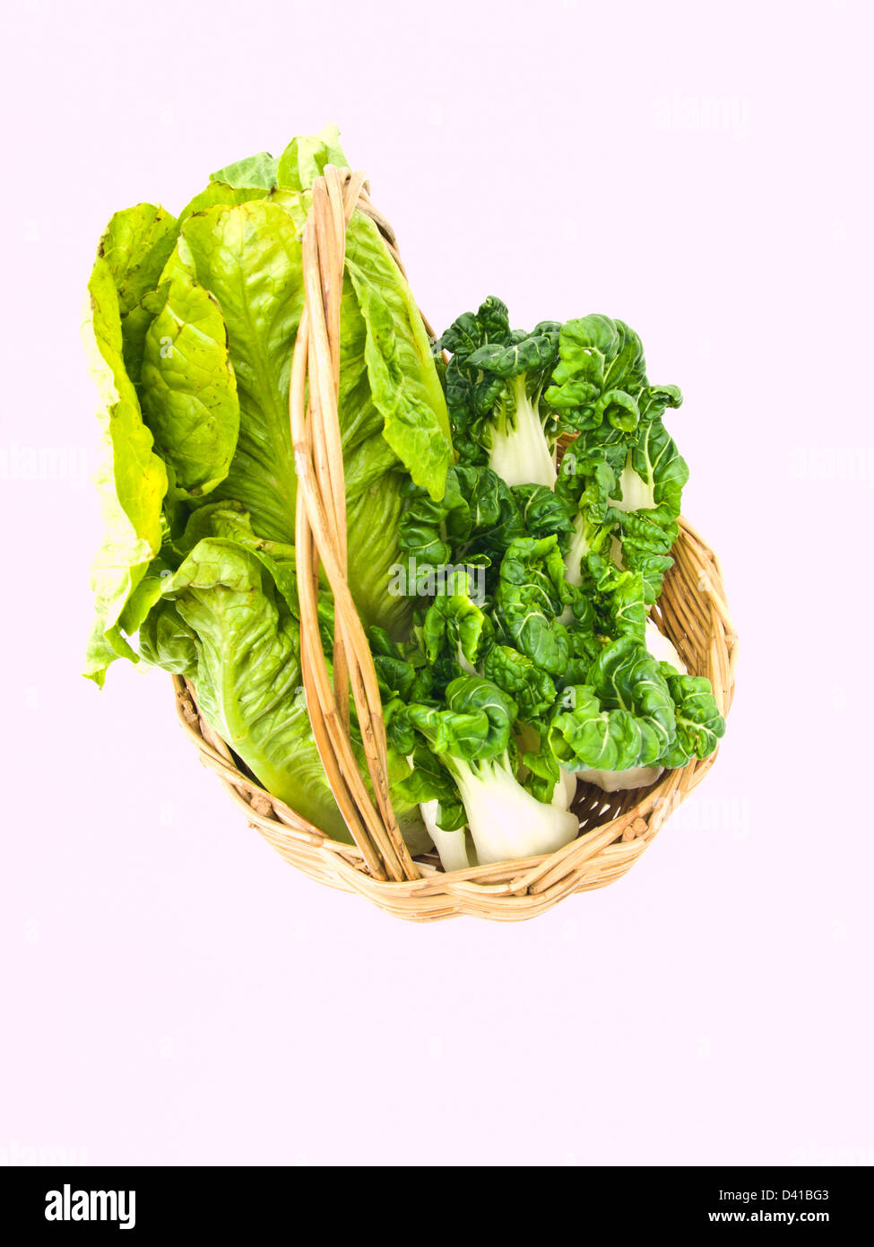 Des petits bok choy et cos salade en rotin panier isolé sur fond blanc Banque D'Images