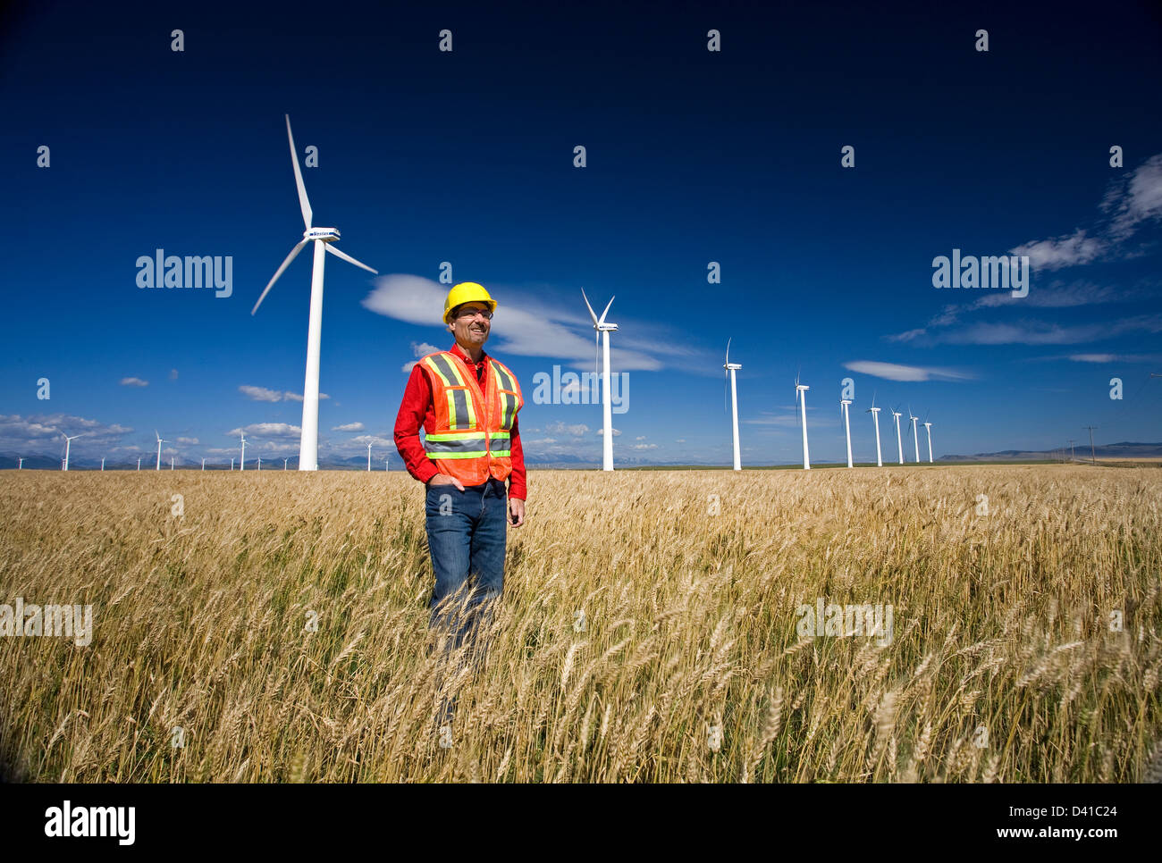 Technicien en énergie éolienne debout à côté d'éolienne, Pincher Creek, Alberta, Canada Banque D'Images