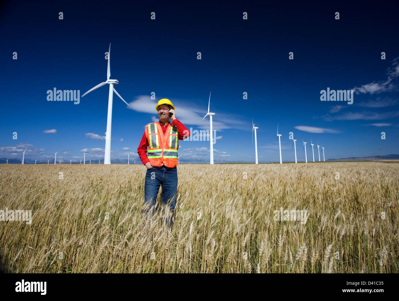 Technicien en énergie éolienne debout à côté d'éolienne, Pincher Creek, en Alberta. Le Canada. Banque D'Images